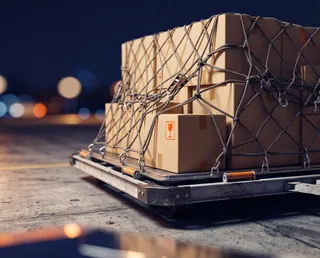 Cajas de carga aérea aseguradas con red sobre un pallet en la pista del aeropuerto